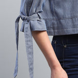 Blue checkered shirt with a tie waist on a gray background