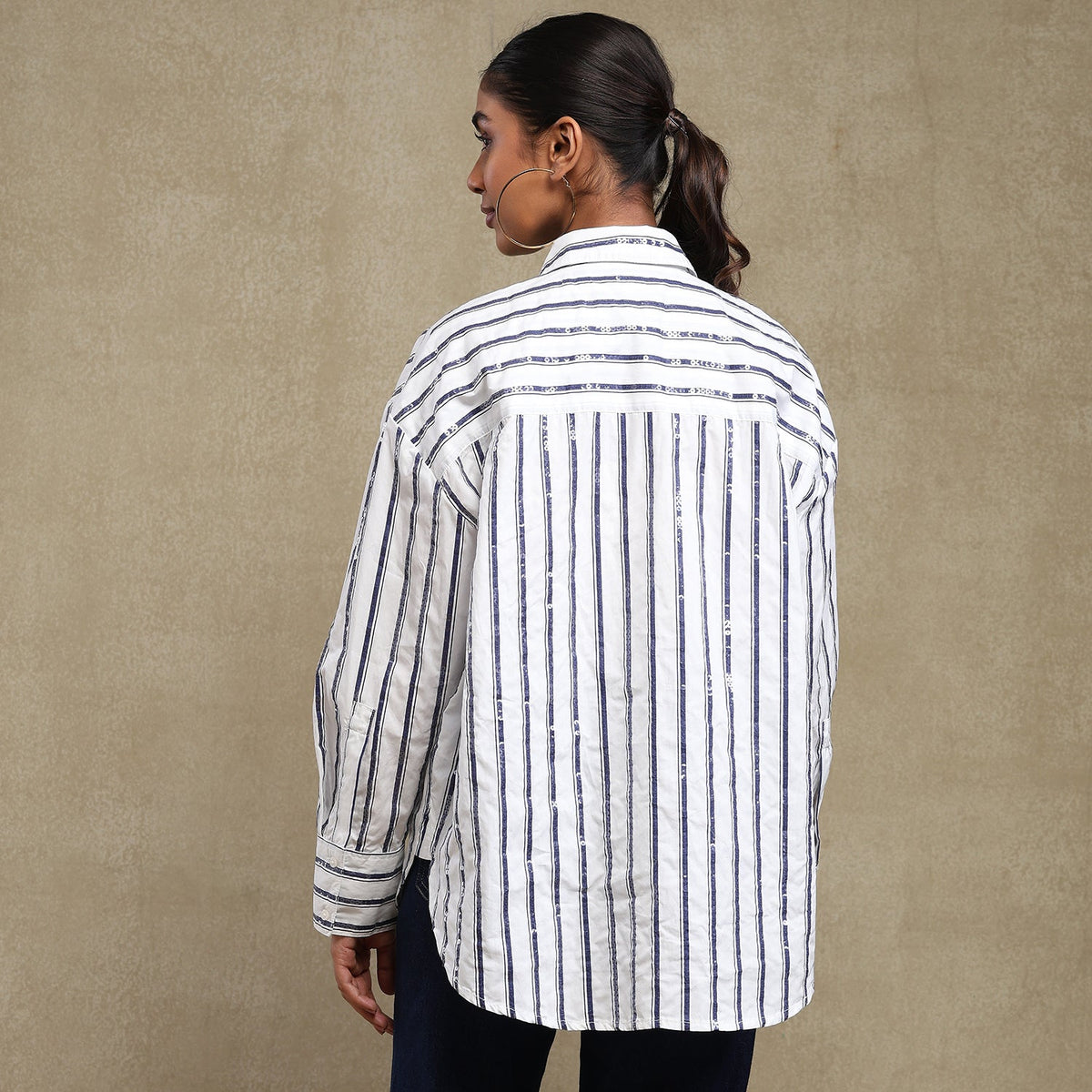 Person wearing a striped shirt against a beige background