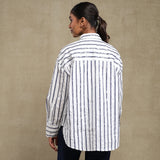 Person wearing a striped shirt against a beige background